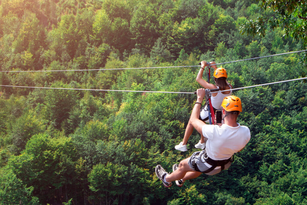 couple ziplining over mountains