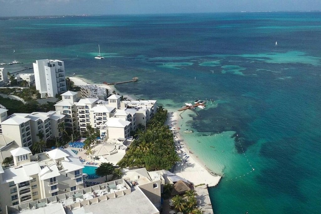 Aerial view of hotels along Cancun’s coast, one of the warm getaways outside the U.S.